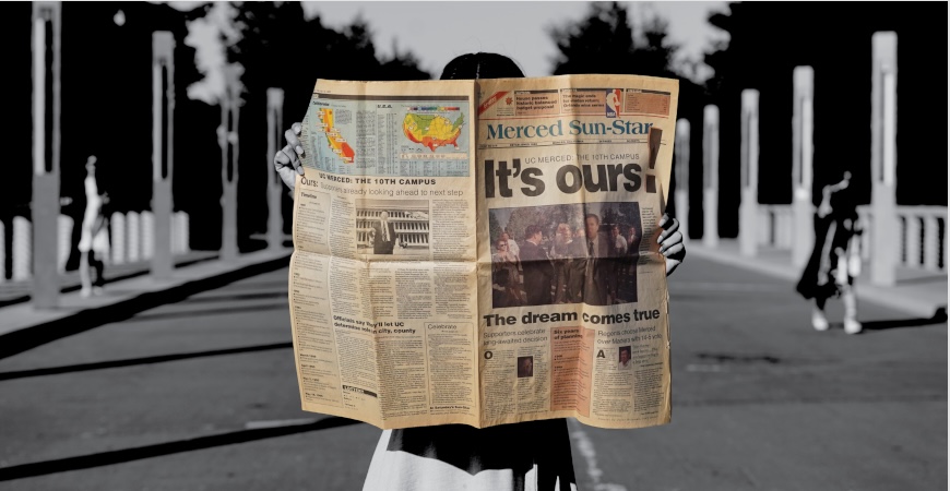A student holds a copy of the Merced Sun-Star, with a large headline proclaiming 