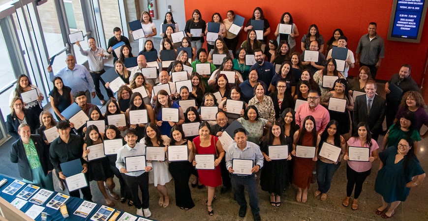 A large group of UC Merced Extension students holding up their certificates is pictured.