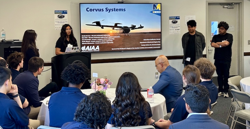Photo depicts the UC Merced team using a large screen to present its project.