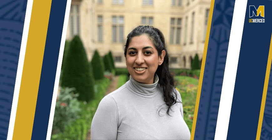 Female with brown hair in cream turtle neck top in front of building