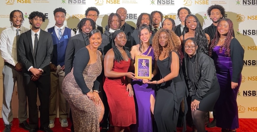 Members of UC Merced's chapter of the National Society of Black Engineers are pictures with a plaque.