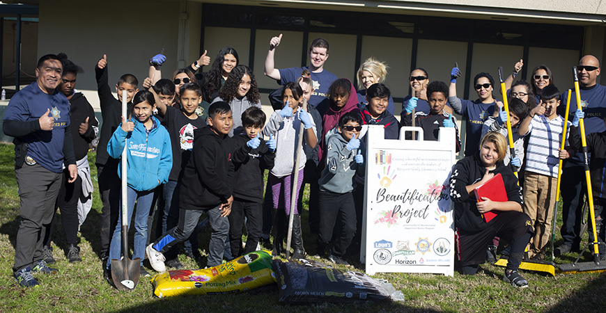 UC Merced Police Department officers, student mentors and Margaret Sheehy Elementary School students gather for a group photo during their beautification project.