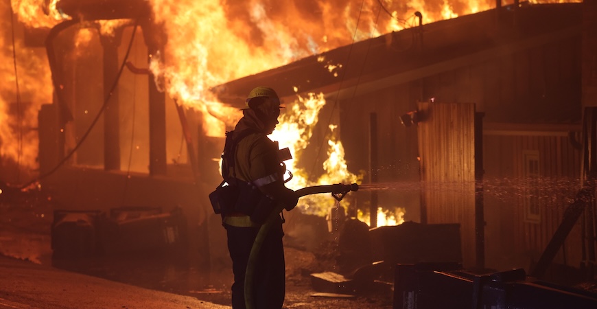 Photo depicts a firefighter battling a blaze at a Southern California home during the Palisades fire in January 2025.